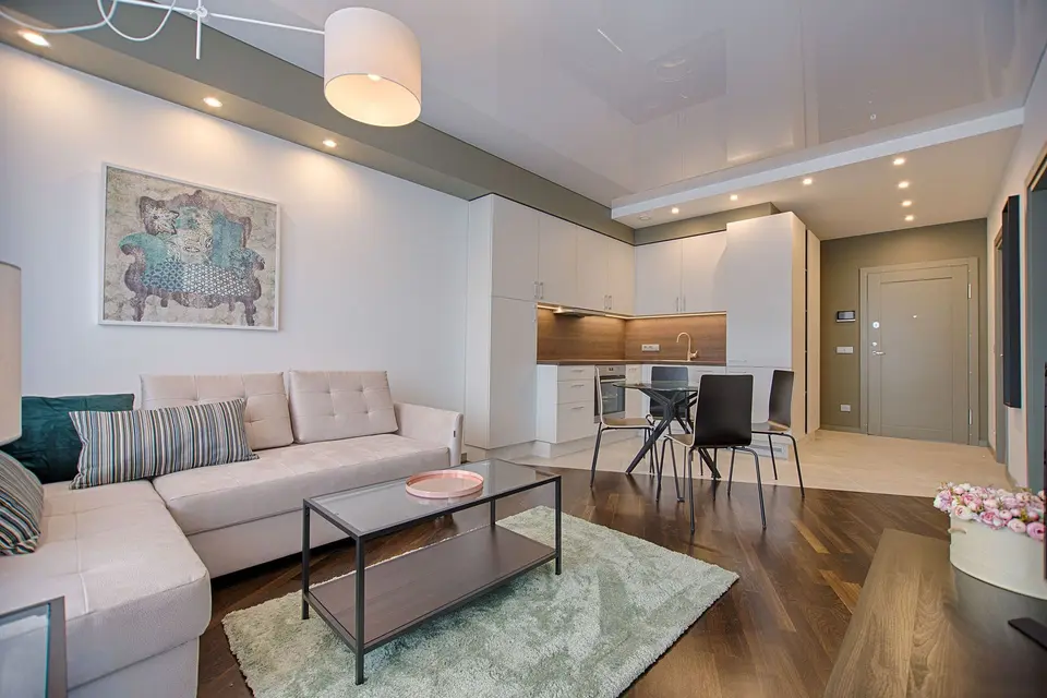 Modern living room with a large sofa and an open kitchen